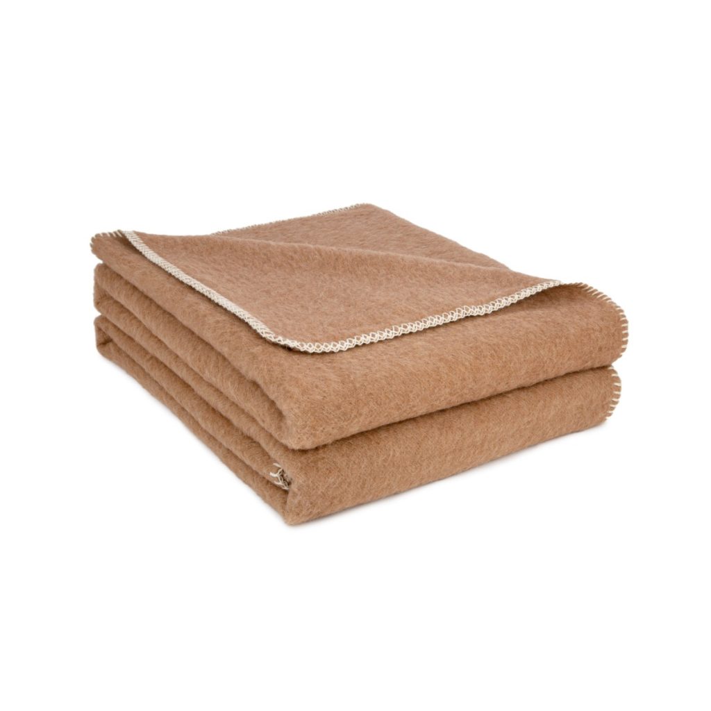 Plaid en laine couleur chamois plié, bordé d'un point de feston blanc