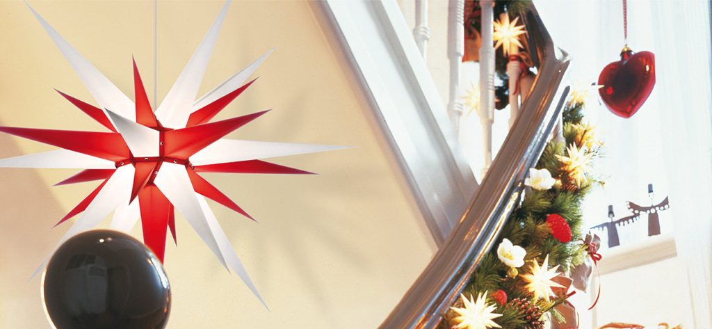 Étoile de Herrnhut rouge et blanche suspendue dans une cage d'escalier décorée pour Noël